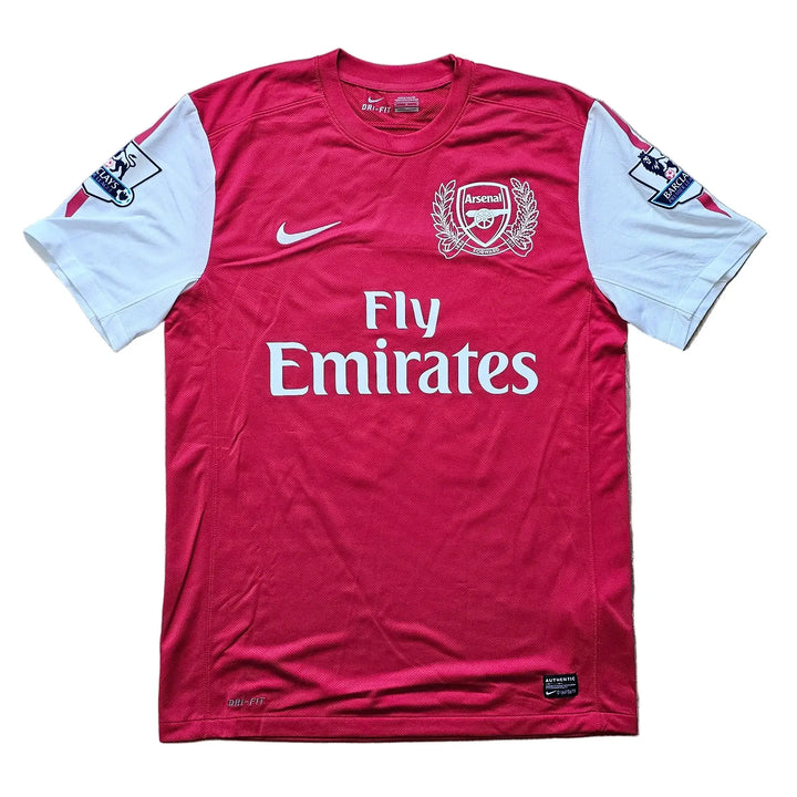 Front of a red and white Arsenal 2011-12 home shirt with the Nike swoosh, Arsenal crest, and Fly Emirates sponsor across the chest, No. 10.