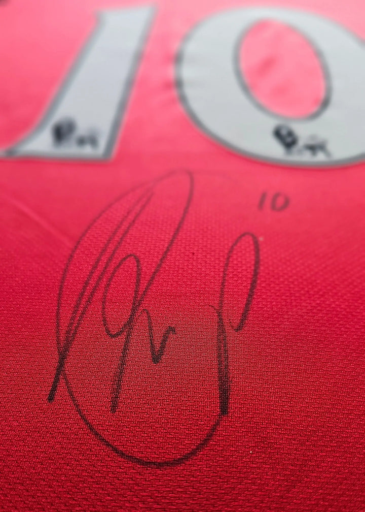 Close-up of a black ink autograph beneath the number 10 on a red Arsenal shirt, Robin van Persie's signed No. 10, 2011-12 season.