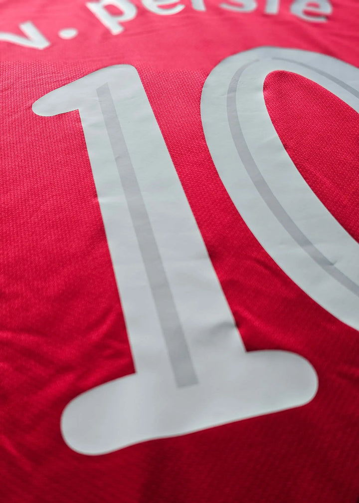 Close-up of the large white number 10 with the persie nameplate partly visible above, on the back of Robin van Persie's Champions League shirt.