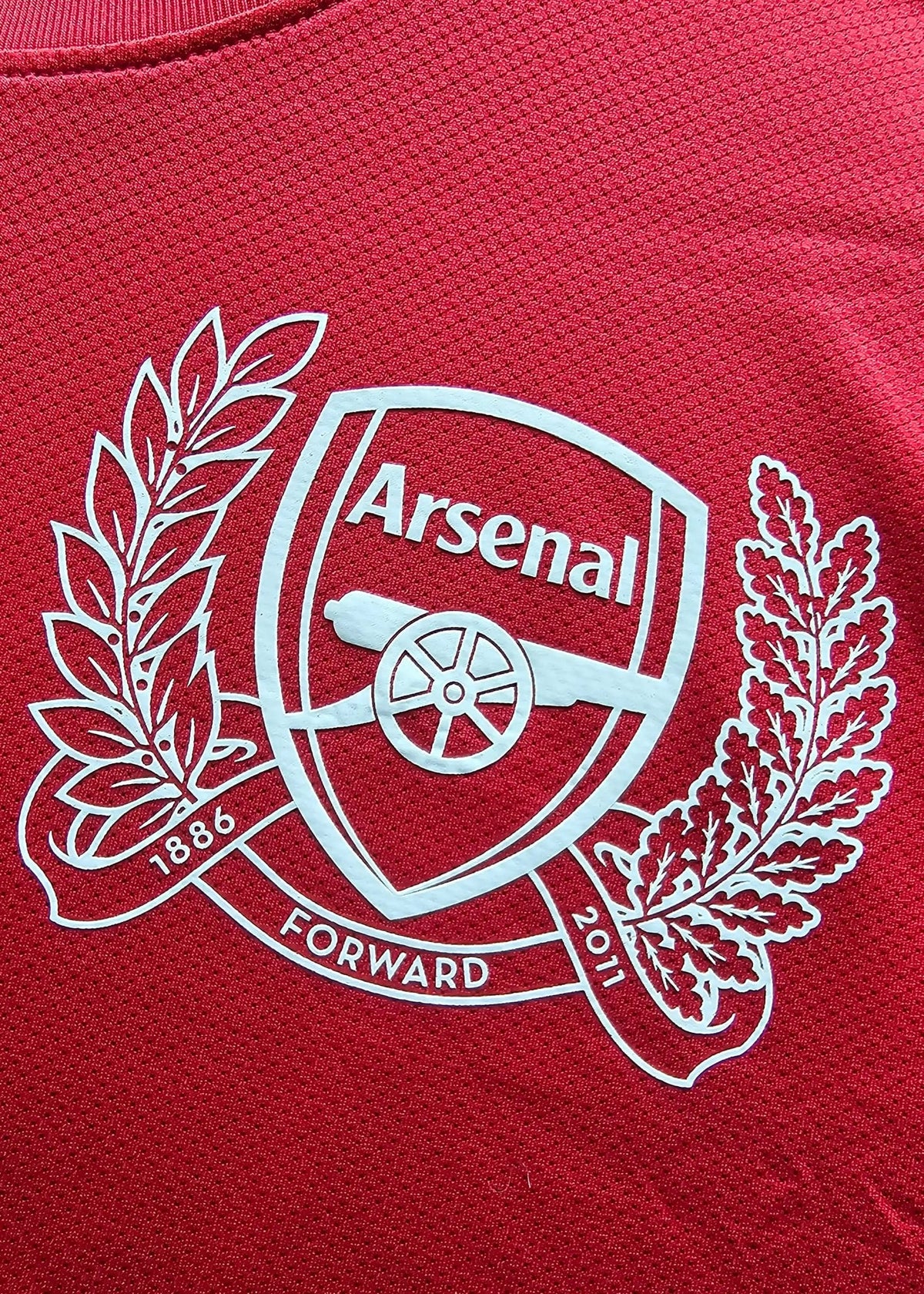 Arsenal crest with cannon and a '1886 Forward 2011' ribbon, embroidered on Robin van Persie's signed Arsenal 2011-12 Champions League No. 10 shirt.