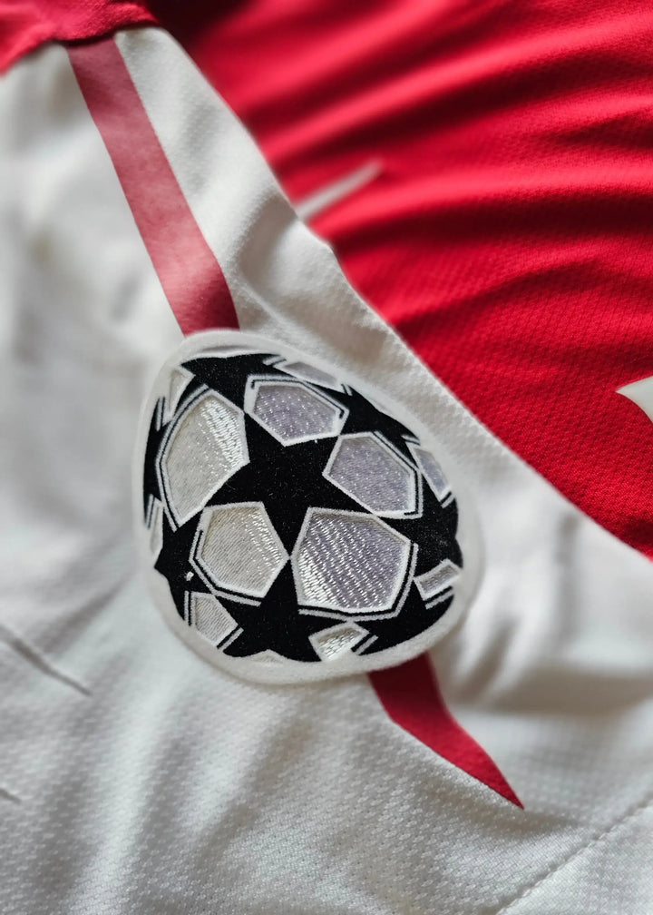 UEFA Champions League starball patch on the white sleeve trim, from Robin van Persie's signed Arsenal 2011-12 No. 10 shirt.