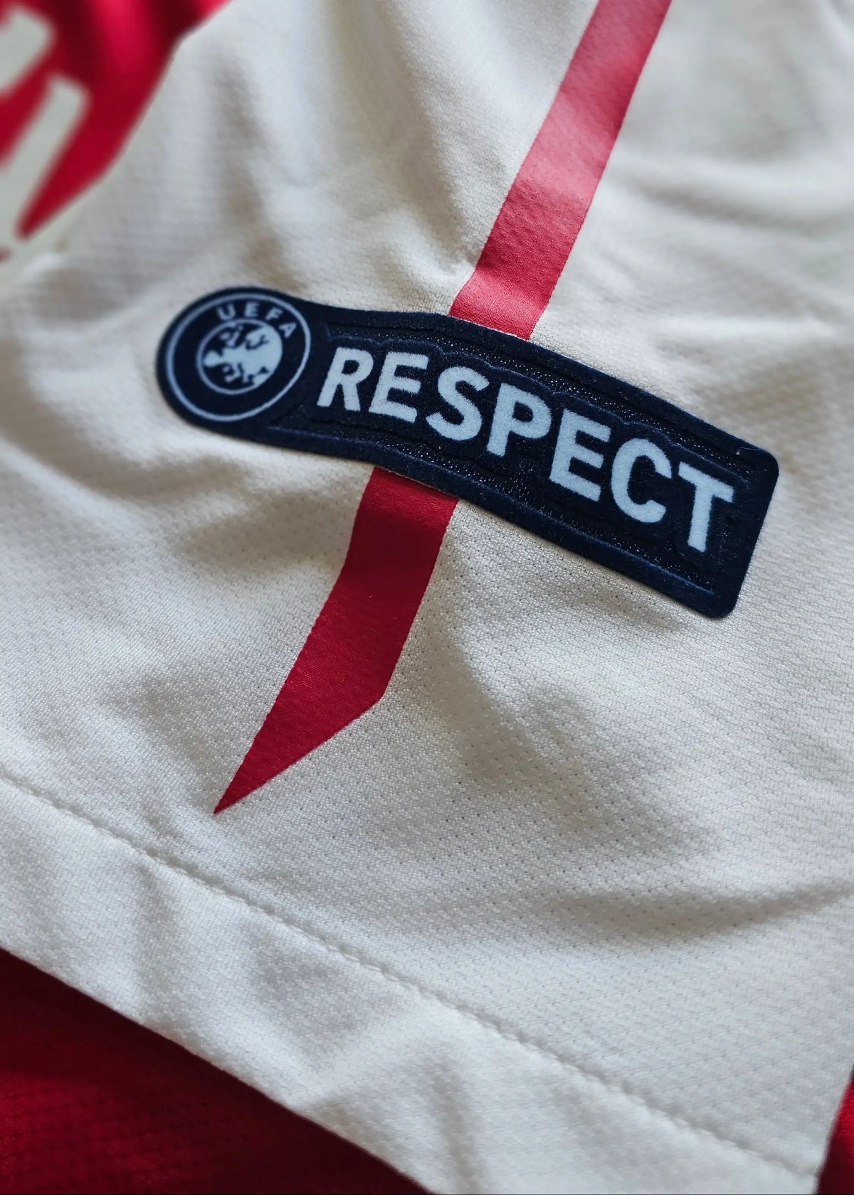 UEFA Respect patch with badge crest on the white sleeve, from Robin van Persie's signed Arsenal 2011-12 Champions League No. 10 shirt.