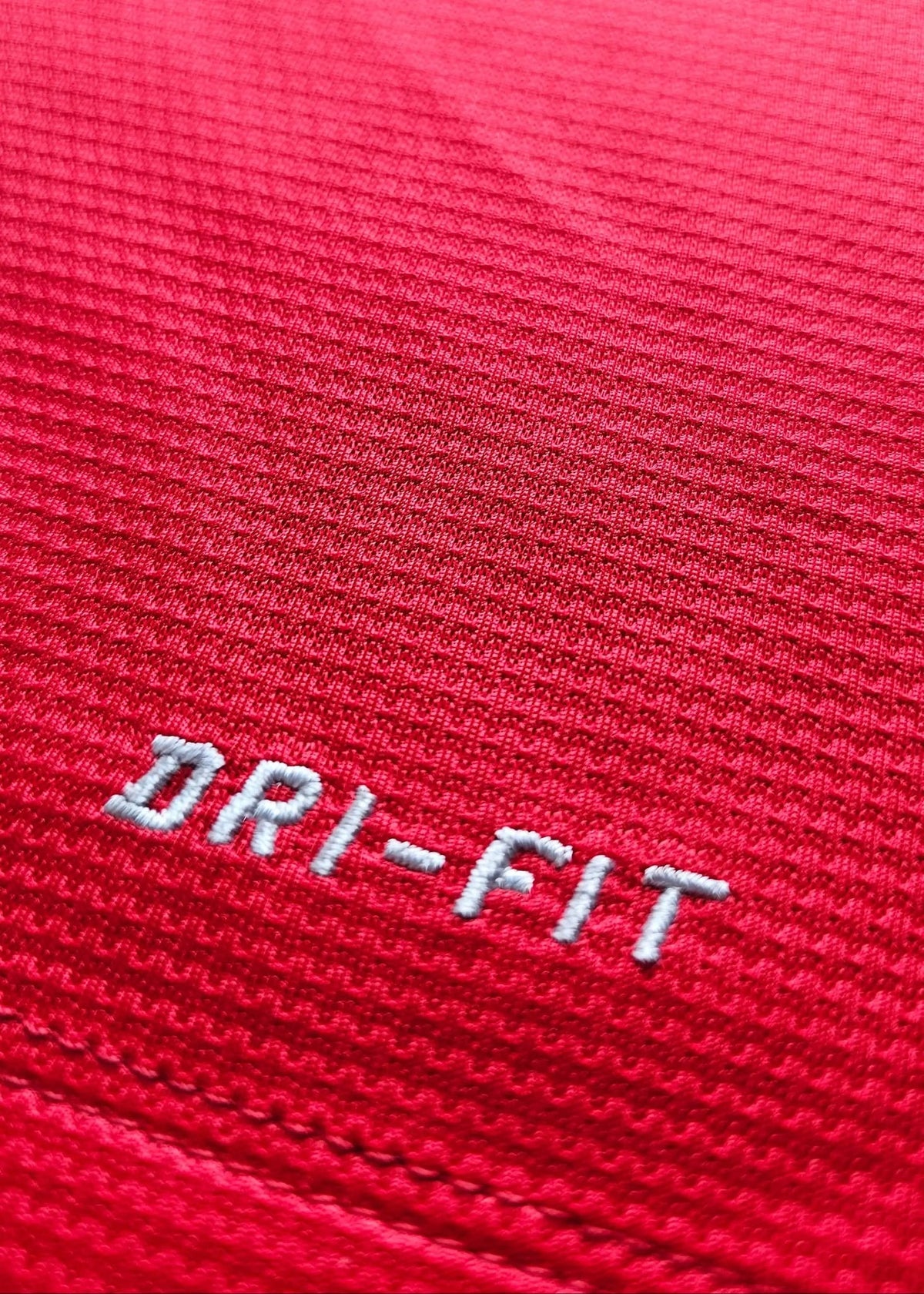 Close-up of the embroidered Nike DRI-FIT tag on the red chest, from Robin van Persie's signed Manchester United 2014-15 No. 20 shirt.