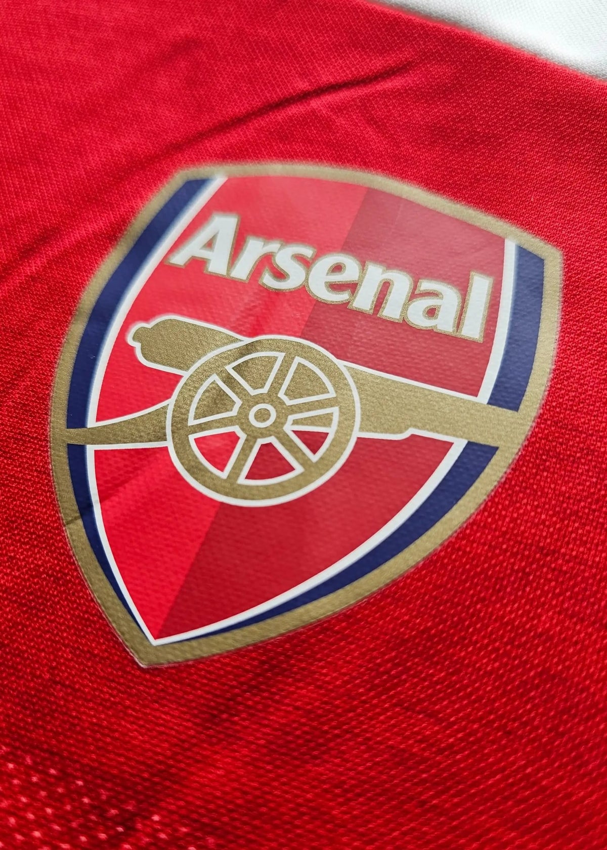 Close-up of the Arsenal Football Club crest with its gold cannon emblem, from Vivianne Miedema's 2018-2019 shirt.