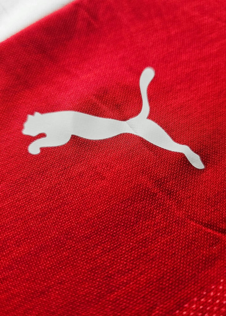 Close-up of the white Puma cat logo on the shirt's red fabric, from Vivianne Miedema's 2018-2019 Arsenal shirt.