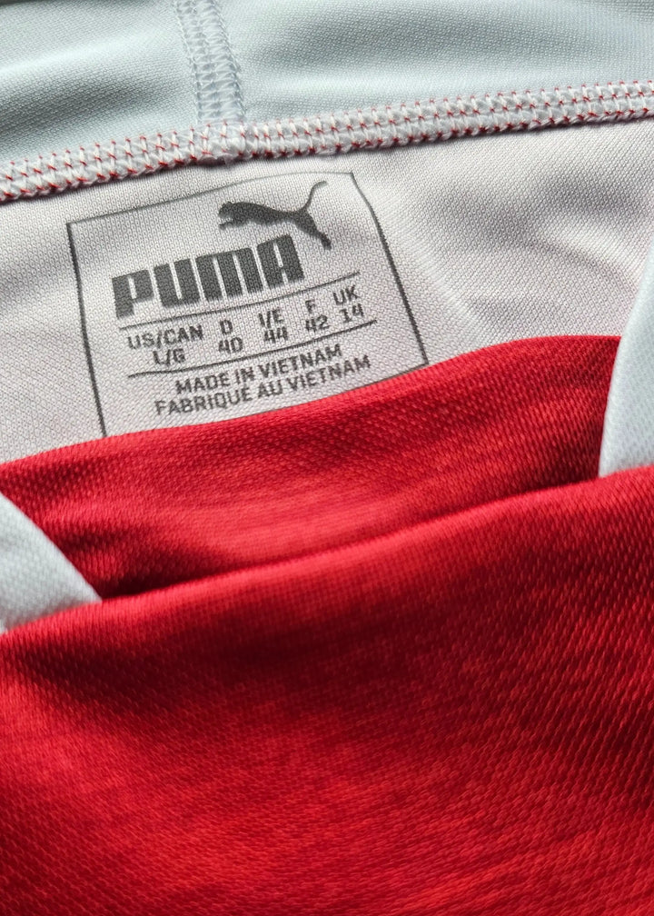 Close-up of the sewn-in Puma size label reading UK 14 and 'Made in Vietnam', from Vivianne Miedema's 2018-2019 Arsenal shirt.