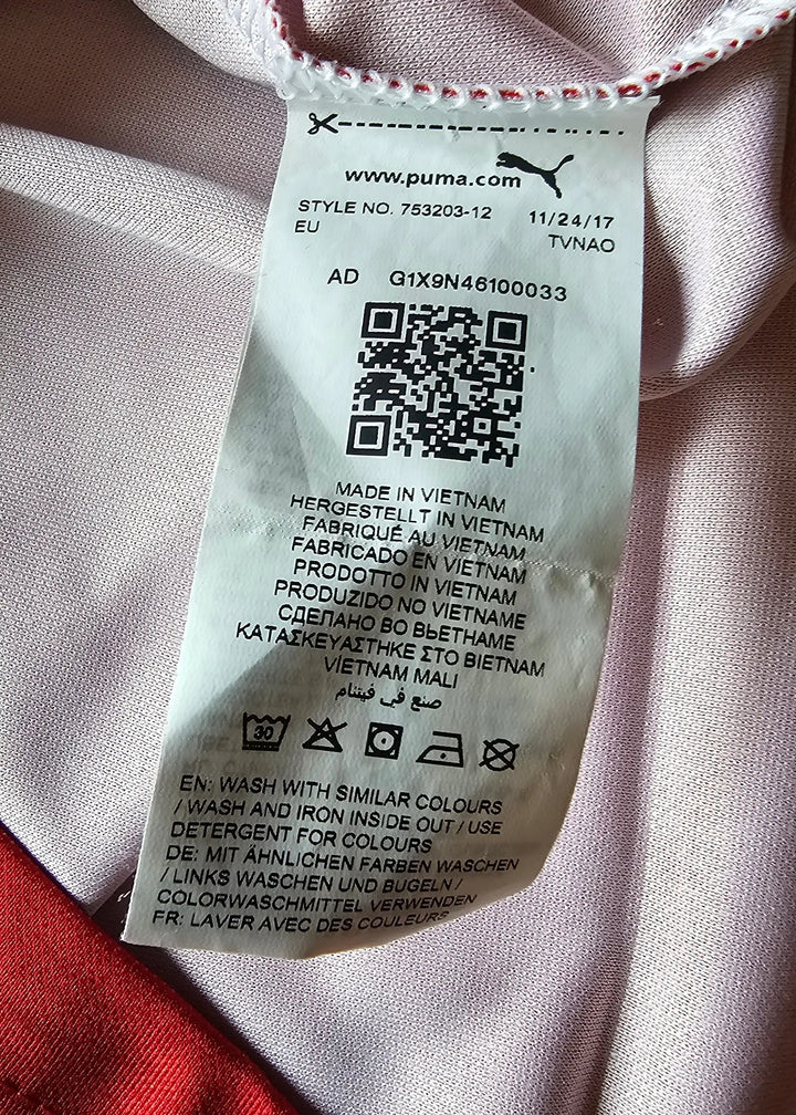 Close-up of the sewn-in Puma care label with wash instructions and a 'Made in Vietnam' origin print, from Vivianne Miedema's 2018-2019 Arsenal shirt.