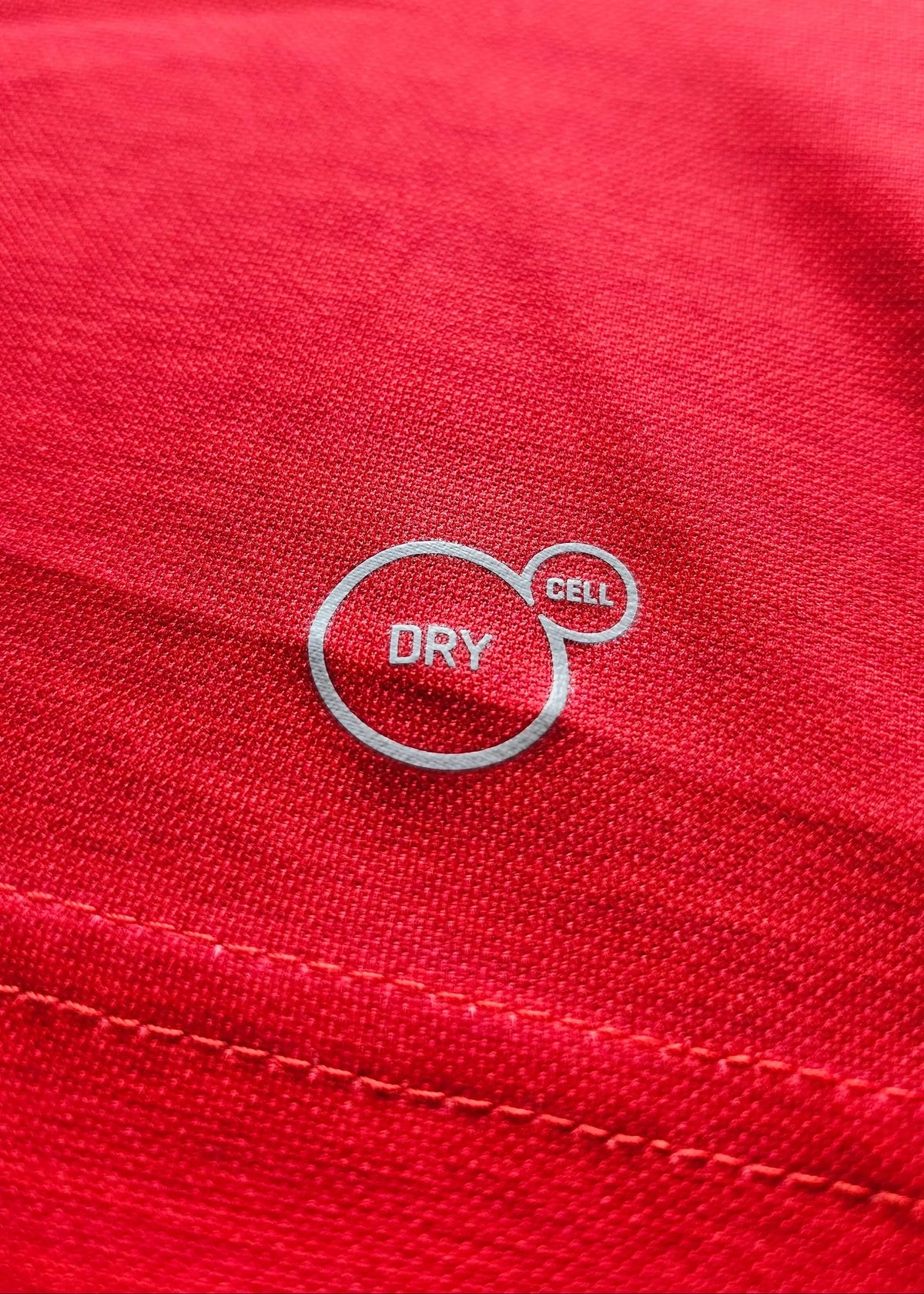 Close-up of the white 'Dry Cell' performance fabric print on the shirt's red body, from Vivianne Miedema's 2018-2019 Arsenal shirt.